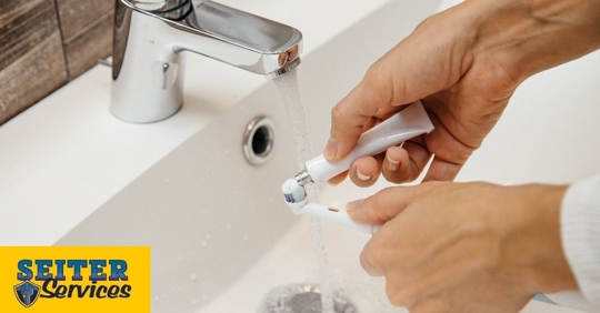 A person putting toothpaste on their toothbrush.